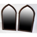 A pair of stained pine Gothic style wall mirrors, height 117 x 65cm.