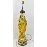 An unusual pottery figural table lamp depicting an Indian deity.