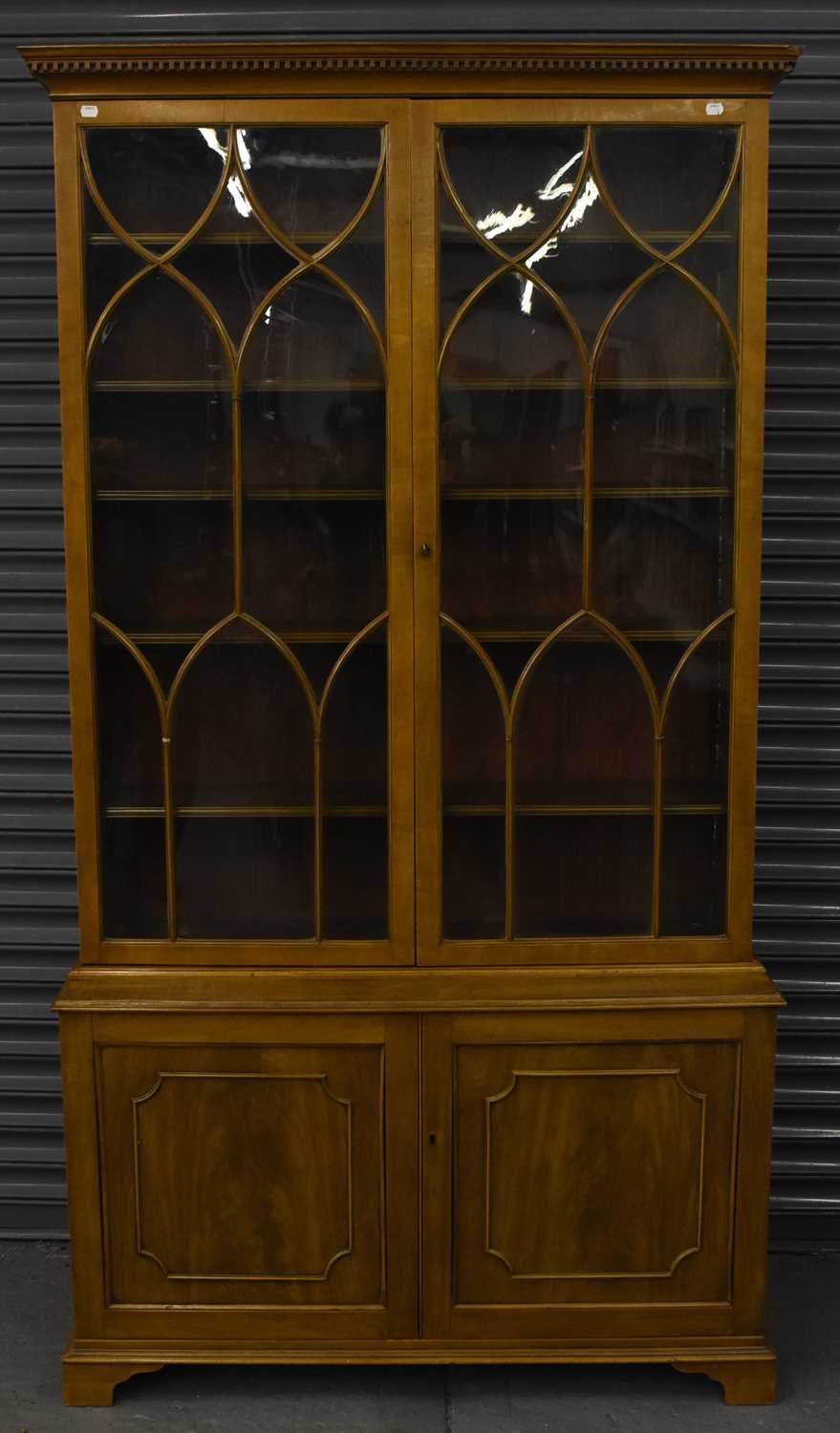 A late 19th century walnut bookcase, the upper section with Gothic style glazing above a pair of