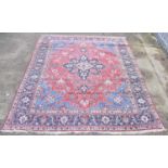 A Persian design rug with central red ground lozenge on a blue field with floral stylised border,