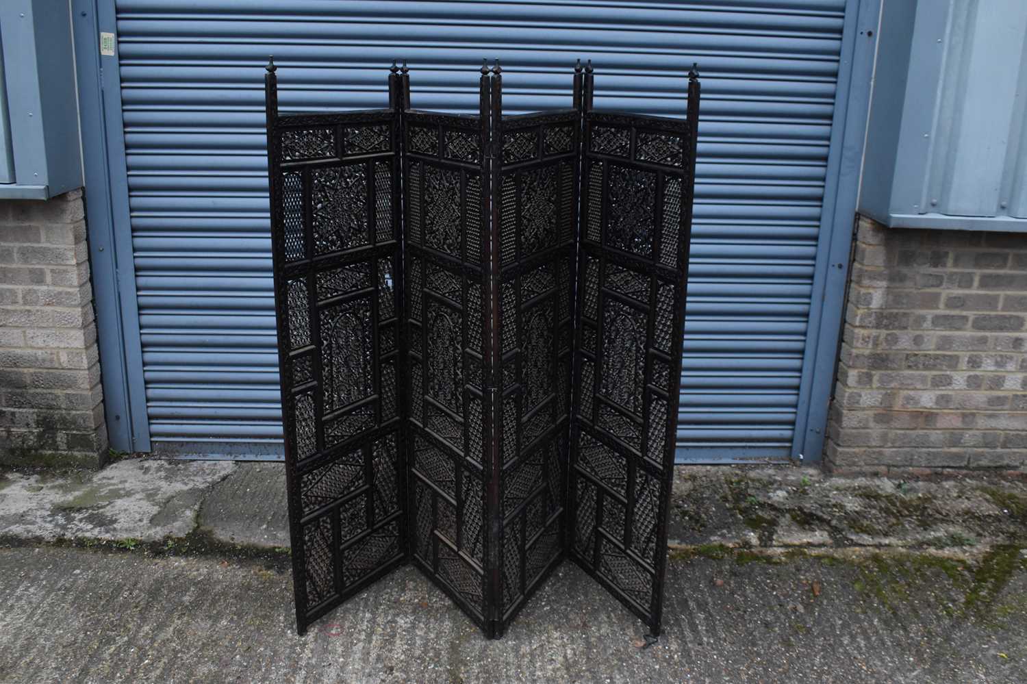An Eastern carved and pierced hardwood four leaf folding screen, height 150cm to top of finial.