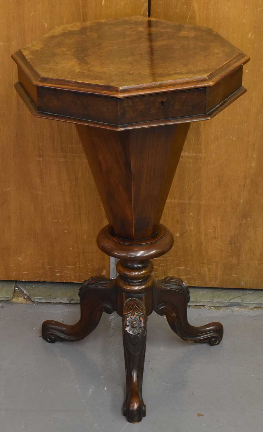 A Victorian walnut 'trumpet' sewing table with octagonal top above tapering central column to