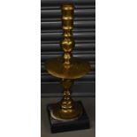 A tall antique brass Chinese lampstand with engraved decoration.