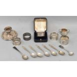 A mixed lot of hallmarked silver including five assorted napkin rings, various spoons, and a small