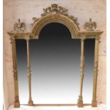 An ornate 19th century gilt wall mirror with domed crested top flanked by urns and with column