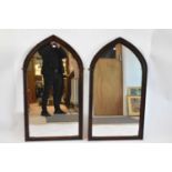 A pair of stained pine Gothic style wall mirrors, height 117 x 65cm.