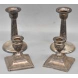 Two pairs of hallmarked silver candlesticks, Birmingham 1910 and 1911, height 12.5cm and 7.5cm