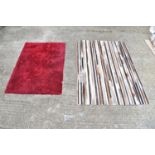 A large multi skin rug and a red chenille style rug.