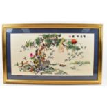 A gilt framed Oriental silk picture depicting birds in trees, 90cm x 46cm, framed and glazed.