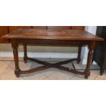 A Continental walnut dining table with rectangular top on turned supports united by an X-shaped