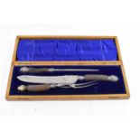 A late Victorian oak cased three piece carving set with antler handles and silver mounts.