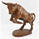 A large carved wooden figure of a rearing bull, height 35cm.