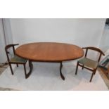 A teak dining suite comprising extending table and set of four chairs.