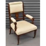 An Edwardian inlaid mahogany upholstered open armchair on ring turned supports.