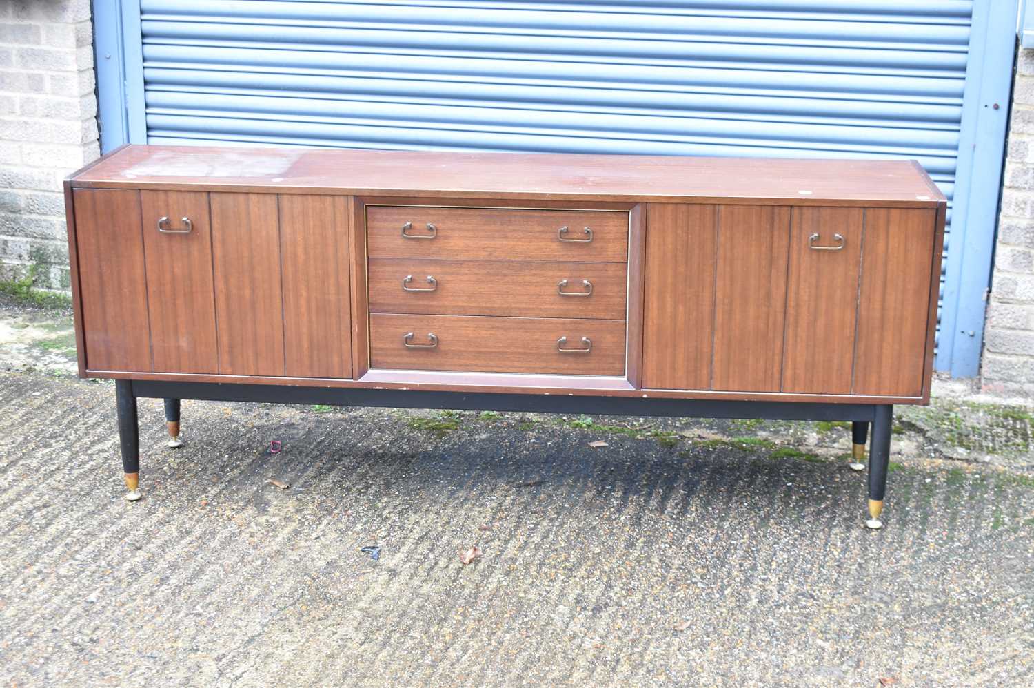 A mid-century sideboard with three central drawers flanked by two cupboard doors, width 191cm, a