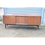 A mid-century sideboard with three central drawers flanked by two cupboard doors, width 191cm, a