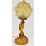 An Art Deco amber coloured glass figural lamp with shade, height approx 40cm.