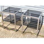 A pair of contemporary chrome square section coffee tables with two black glass tiers.