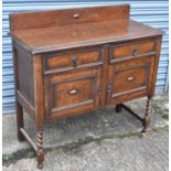 An oak sideboard with beaded decoration on barley twist legs.