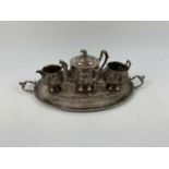 X An Indian silver four piece tea service, decorated with typical scenes of animals and village