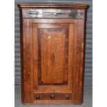 An early 19th century oak and mahogany crossbanded straight front wall hanging corner cupboard
