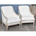A pair of modern cream upholstered armchairs on turned legs, from Andrew Martin.