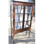 An Edwardian mahogany and inlaid display cabinet with two astragal glazed doors above two drawers,