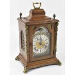 A 20th century oak cased mantel clock formed as a bracket clock, with brass mounts, height to top of