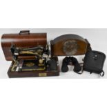 A cased Singer sewing machine, a large Art Deco style mantel clock, and a cased pair of Prinz 12 x