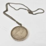 A silver Austrian thaler mounted and suspended on a chain, approx 41.9g.