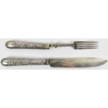 A large Victorian hallmarked silver fruit serving knife and fork, the handles with embossed