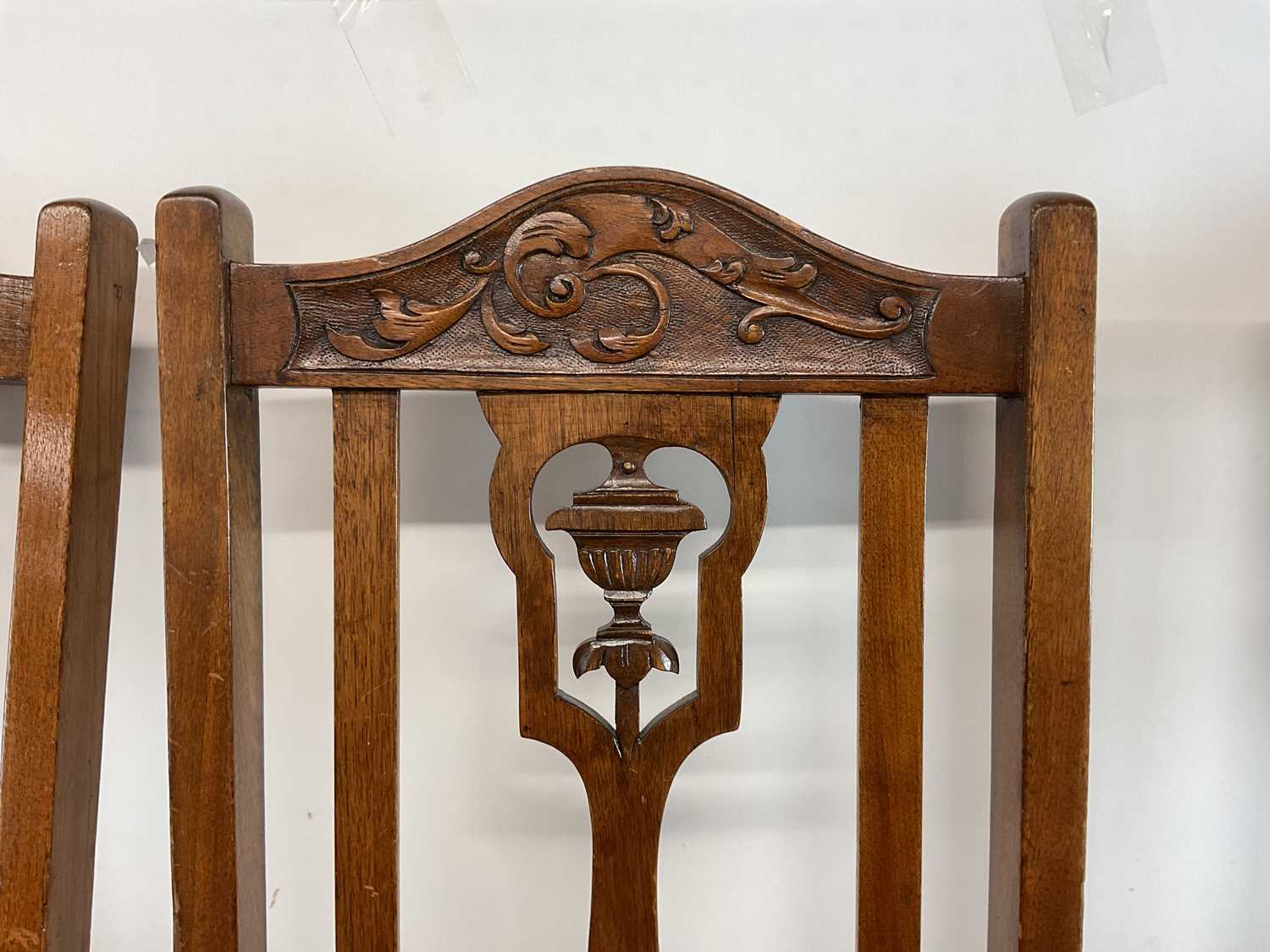 A set of four carved oak upholstered dining chairs with central urn decoration on pad feet. - Image 2 of 3
