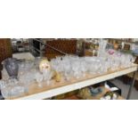 A large collection of various cut glass and coloured glass items including jugs, vases, bowls, etc.