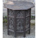 A Moorish carved hardwood octagonal table on folding base, 63cms high and 60cms diameter