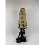 A 1950's mid 20th century African lady figural table lamp with original shade, top of shade to base,