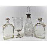 A cut glass decanter with London hallmarked silver collar, a pair of gilt decorated decanters, and