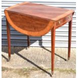 An early 19th century mahogany and satinwood crossbanded oval Pembroke table with end table on