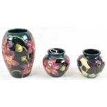 MOORCROFT; two small floral decorated vases, and a large blue glazed vase, all from the