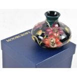 MOORCROFT; a dark blue and green glazed vase decorated with flowers from the Connoisseur collection,