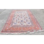 A hand knotted Persian design rug decorated with scrolling foliage on a cream ground 366 x 228cm.