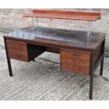 A mid-twentieth century rosewood effect six drawer kneehole desk, width 140cm.