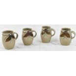 A set of four studio pottery mugs with painted decoration, height 10.5cm.