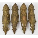 A set of four large ornate brass furniture mounts, length 34cm.