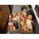 A box of assorted dolls and soft toys.