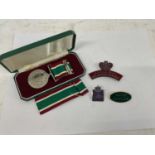 A cased Women's Voluntary Service medal and three badges.