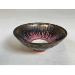 † PETER WILLS; a conical bowl drip glazed on a pink ground, impressed and incised marks to base,