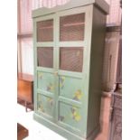 A vintage green painted food cupboard with mesh grill to the upper sections and painted detail to