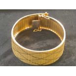 A textured 9ct gold broad flat link bracelet, length 18cm, approx. 27.7g.