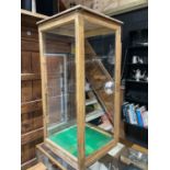 A pine framed glazed display cabinet with mirrored vertical sliding rear door, height 95cm, width