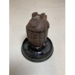 An unusual World War I memento formed of a hand grenade converted to an inkwell, now mounted on a